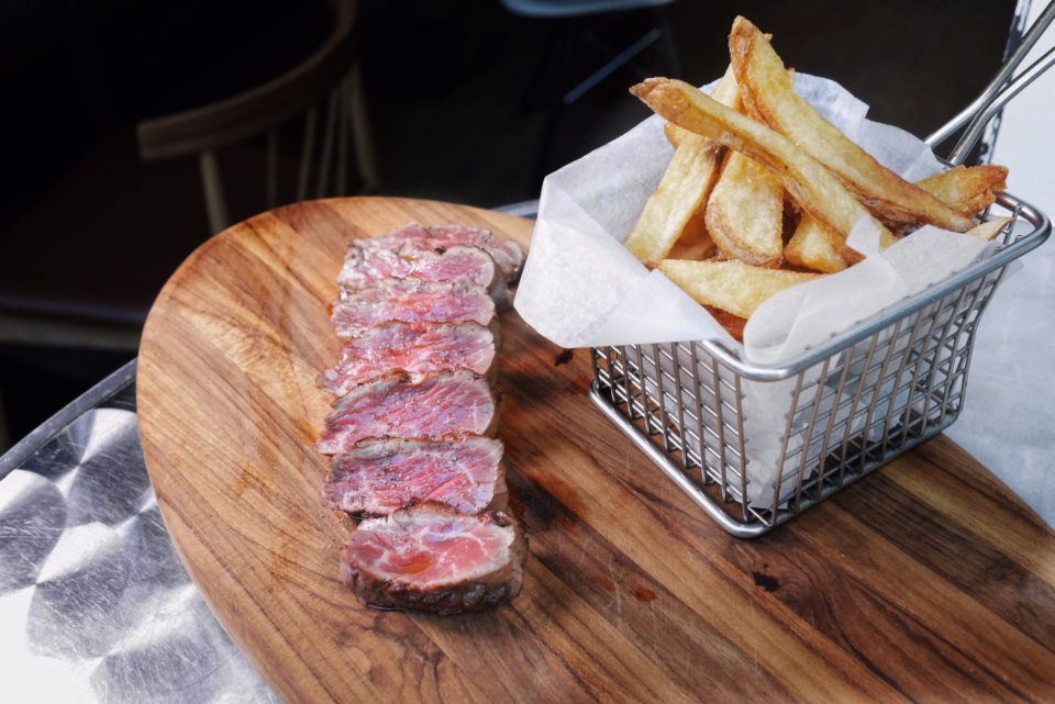 Grillat kött och pommes frites på träbricka